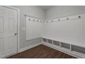 Functional mudroom boasts a built-in bench with cubbies, wood-look flooring and crisp white trim at 2057 Big Falls Dr, Wendell, NC 27591