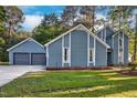 Beautiful blue home with large garage and well-manicured lawn, perfect for outdoor enjoyment at 206 Cottrell Dr, Louisburg, NC 27549
