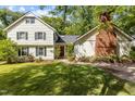 Traditional two-story home with a charming brick chimney, lush landscaping, and well-manicured front lawn at 2113 Port Royal Rd, Raleigh, NC 27609