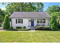 Cozy home exterior showing well-manicured lawn and landscaping, a blue door, and comfortable seating at 2210 Milburnie Rd, Raleigh, NC 27610