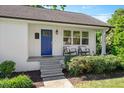 Charming front porch with rocking chairs and a blue door creates a welcoming entrance to the home at 2210 Milburnie Rd, Raleigh, NC 27610