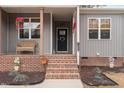 Inviting front porch with brick steps, a cozy seating area, and attractive decorations at 2690 Meadow View Ln, Sanford, NC 27332