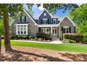 Charming two-story home with stone and shingle siding, manicured lawn, and inviting front porch at 30 Ocoee Falls Dr, Chapel Hill, NC 27517