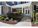 Inviting front porch with stone accents, double doors, and manicured landscaping at 30 Ocoee Falls Dr, Chapel Hill, NC 27517