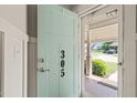 View through the front door showing the covered porch, manicured lawn and landscape, and the street beyond at 305 E Holmes St, Benson, NC 27504