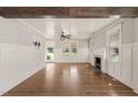 Open concept living room with a hardwood floor, light grey walls, a fireplace, and large windows for natural light at 305 E Holmes St, Benson, NC 27504