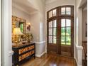 Elegant foyer boasts hardwood floors, a stylish mirror, and a decorative wooden front door at 3403 Raccoon Run Dr, Burlington, NC 27215