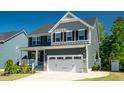 Charming two-story home featuring a two-car garage, yellow door, and inviting front porch, perfect for suburban living at 3678 Horton Hill Dr, New Hill, NC 27562