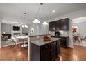 Open concept kitchen features dark wood cabinetry, granite countertops, and hardwood flooring at 4 Seawell Ct, Durham, NC 27703