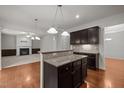 Open concept kitchen features dark wood cabinetry, granite countertops, and hardwood flooring at 4 Seawell Ct, Durham, NC 27703