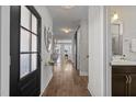 Inviting hallway featuring a dark front door, light walls, wood floors and sliding barn door at 43 Quarter Gate Trce, Chapel Hill, NC 27516