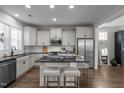 Well-lit kitchen featuring stainless steel appliances, a kitchen island with seating and dark granite countertops at 43 Quarter Gate Trce, Chapel Hill, NC 27516