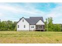 Spacious backyard showcasing a newly built home with a screened in porch and green yard at 474 Pine Ridge Rd, Zebulon, NC 27597