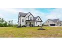 Inviting two-story house with a covered porch and a blue front door, surrounded by greenery at 474 Pine Ridge Rd, Zebulon, NC 27597