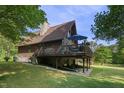 Exterior of the home with a large wrap-around deck and stone foundation at 506 Burgess Rd, Apex, NC 27523