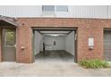 View of an empty garage featuring laundry appliances, exposed brick, and a concrete floor at 506 N Mangum St # 402, Durham, NC 27701