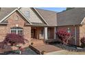 Close up of the home's brick entrance, featuring a covered porch and well-maintained landscaping at 5250 Sartin Rd, Burlington, NC 27217