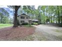 A view of the home showing the long driveway with large trees offering shade and privacy at 5728 Carriagehouse Ct, Apex, NC 27539