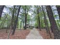 A long winding gravel driveway leads to a home surrounded by lush trees and greenery at 5728 Carriagehouse Ct, Apex, NC 27539