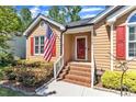 Close-up of a home's entrance, showing a brick stairway, red door and an American flag at 5909 Royal Coach Ct, Raleigh, NC 27612