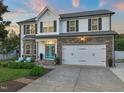Charming two-story home featuring a stone facade, a two-car garage, and a well-manicured lawn at 60 Consella Way, Franklinton, NC 27525