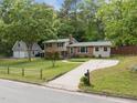 Inviting home with a long driveway leading to a detached garage, surrounded by a lush green lawn and mature trees at 600 Longleaf Dr, Chapel Hill, NC 27517