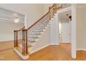Staircase with decorative wrought iron railing and hardwood floors throughout the entry at 7000 Millstone Ridge Ct, Raleigh, NC 27614