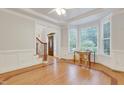 Living area with hardwood floors, natural light from bay window and stairway access at 7000 Millstone Ridge Ct, Raleigh, NC 27614