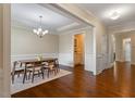 Elegant dining room featuring hardwood floors, wainscoting, and a modern chandelier at 704 Long Lake Dr, Fuquay Varina, NC 27526