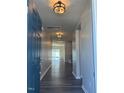 Inviting entryway with hardwood floors and modern lighting fixtures throughout the hallway at 712 Emmer St, Rolesville, NC 27571