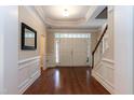 Grand foyer with gleaming hardwood floors, a staircase, and a view of the front doors at 7660 Channery Way, Raleigh, NC 27616