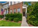 Close-up of a townhome entrance with lush green hedges and a walkway leading to the front door at 7761 Winners Edge St, Raleigh, NC 27617