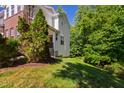 Side view of a townhome's yard with a manicured lawn and mature trees offering shade and privacy at 7761 Winners Edge St, Raleigh, NC 27617