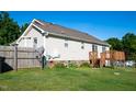 Fenced backyard featuring a wooden deck, grassy lawn, and mature trees at 78 Cross Creek Ct, Timberlake, NC 27583