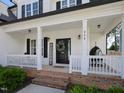 Inviting covered front porch with seating area, wreath, and decor at 808 Trinity Park Dr, Wake Forest, NC 27587