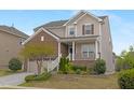 Inviting two-story home featuring a covered front porch, brick accents, manicured lawn, and driveway at 844 Cozy Oak Ave, Cary, NC 27519