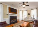 Cozy living room with a fireplace, hardwood floors, and natural light from large windows at 8517 Falkirk Ridge Ct, Wake Forest, NC 27587