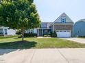 Charming two-story home featuring a stone accented facade, well-manicured lawn, and a double car garage at 90 Heathgreen Dr, Clayton, NC 27527