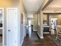 Hallway with dark wood floors and neutral walls leading to living spaces with an open floor plan at 90 Heathgreen Dr, Clayton, NC 27527