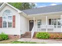 Welcoming front porch with white railings, brick steps and colorful landscaping at 901 N Taylor St, Wake Forest, NC 27587