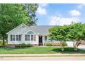 Inviting single-story home with green lawn, lush landscaping and a covered front porch at 901 N Taylor St, Wake Forest, NC 27587