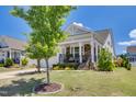 View of the home's facade showcasing the covered front porch and manicured lawn at 94 Two Creeks, Chapel Hill, NC 27517