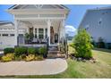 Inviting covered porch with stone pillars and seating area at 94 Two Creeks, Chapel Hill, NC 27517