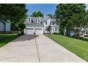 Two-story home with a large driveway and manicured lawn, set against a backdrop of mature trees at 9517 Candor Oaks Dr, Raleigh, NC 27615