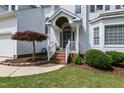 Inviting front entrance with a covered porch, brick steps, and charming landscaping at 9517 Candor Oaks Dr, Raleigh, NC 27615