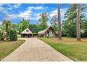 Long driveway leading to a home with a stone facade and an adjacent garage structure at 1003 W Divine St, Dunn, NC 28334