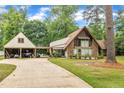 A-frame home featuring a long driveway leading to the attached garage with additional storage at 1003 W Divine St, Dunn, NC 28334