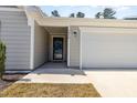 Close-up of the home's entrance featuring a black front door, neutral siding, and an attached garage at 1012 Ringhill Bluff Dr, Durham, NC 27704