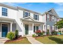 A charming townhome featuring a welcoming porch with columns and beautifully landscaped front yard at 1027 Myers Point Dr, Morrisville, NC 27560
