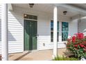 Inviting front porch with white columns, green door and manicured rose bushes at 1027 Myers Point Dr, Morrisville, NC 27560